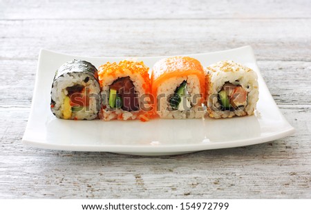 Sushi pieces collection on white plate over wood table