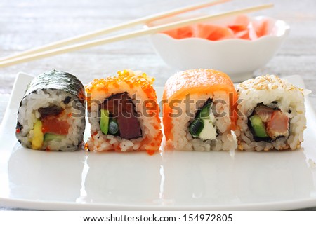 Sushi pieces collection on white plate over wood table