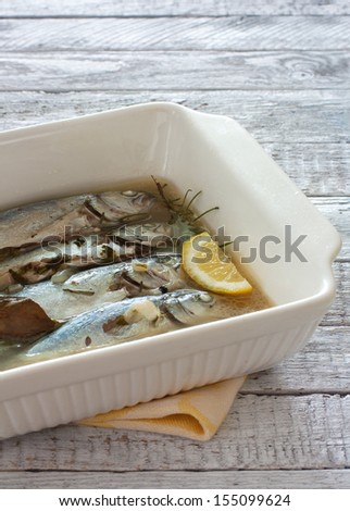 Stew fish with spices in white ceramic form