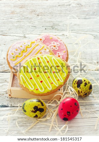 Easter funny cookies and eggs over wood white background