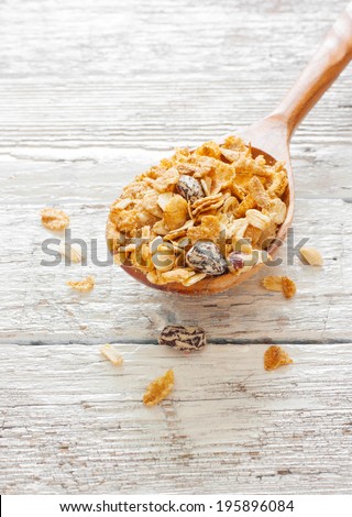 Spoon of muesli over wood background