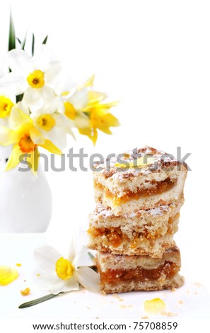 cake with jam and vase with flowers