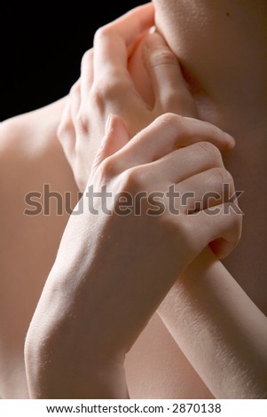 A close-up image of woman\'s hands lying on her shoulder