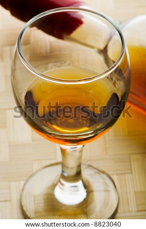 Cognac or similar strong spirit in a glass tumbler beside the bottle