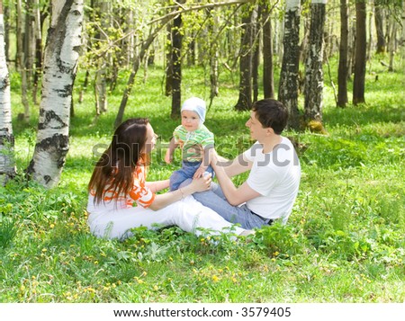Family at nature. Three persons. Grass. Green forest.