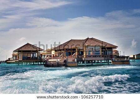 Landscape photo of Island in ocean, overwater villa with endless swimming pools. Maldives.