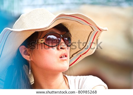 Closeup portrait of a Chinese beautiful girl, with sun glasses and hat