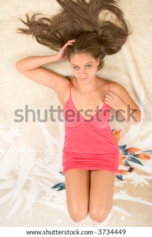 Beautiful female lying down on her back featuring long hair and perfectly shaped legs