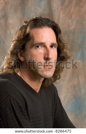 Studio portrait of mid aged man with long hair