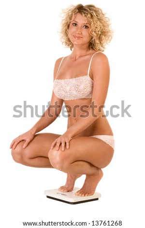 stock photo Attractive girl squatting on bathroom scales checking weight