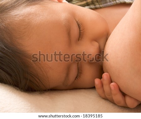 Infant holding his mother breast while she is nursing him