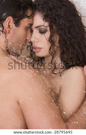 Loving affectionate nude young heterosexual couple in affectionate sensual kiss after taking shower. Mid adult Caucasian men in late 30s and young Latina woman in early 20s