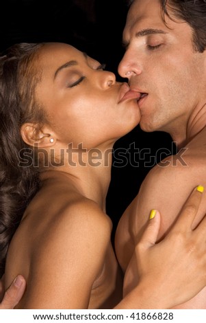 Loving affectionate nude interracial heterosexual couple in affectionate sensual kiss. Mid adult Caucasian men in late 30s and young black African-American woman in 20s