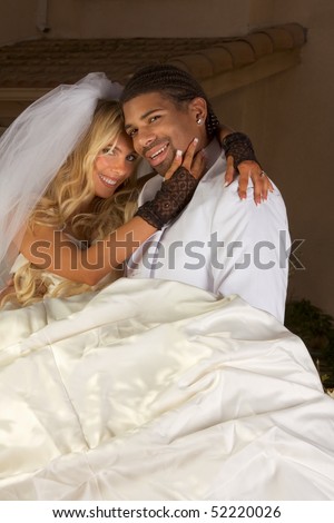 Interracial couple outdoors. Smiling laughing newlywed young Caucasian woman and mid aged ethnic black man of African American and Italian ethnicity