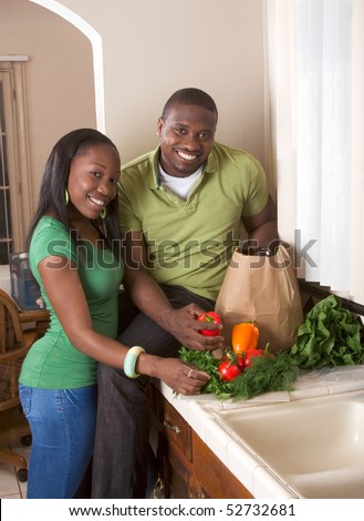 stock photo : Young black African American couple sorting vegetable on kitchen countertop