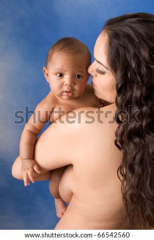 naked Hispanic mom holding her biracial mix of Hispanic and African American baby son against blue background