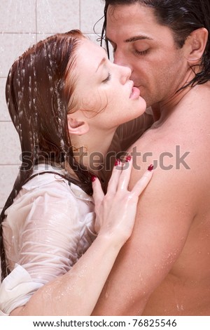Loving affectionate young heterosexual couple in affectionate sensual kiss after taking shower. Mid adult Caucasian men in late 30s and young Caucasian redhead woman in early 20s