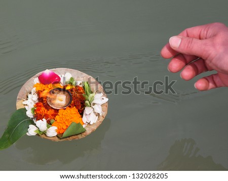 flower arrangement and candle on the ganga river