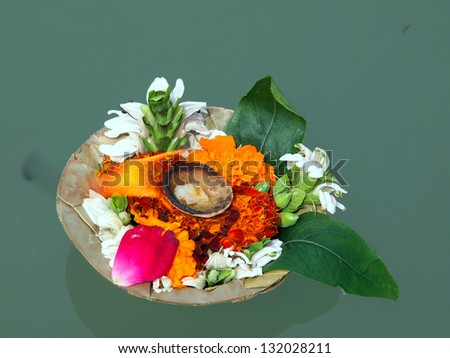 flower arrangement and candle on the ganga river