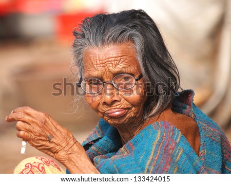 very old indian woman moking cigarette