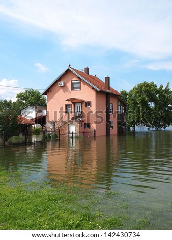 big flooded house with blue sky and white clouds in high water