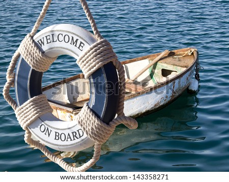old wooden boat on the sea and safe belt with sign welcome on board