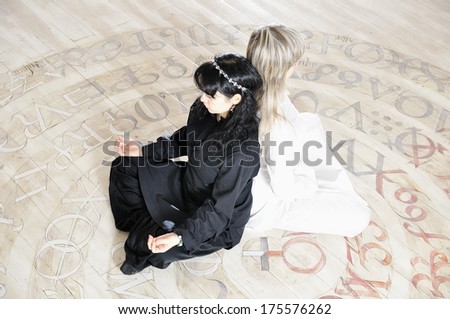 Two young woman black and white dressed doing yoga