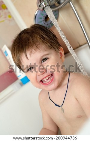 Funny baby bathes in the bath