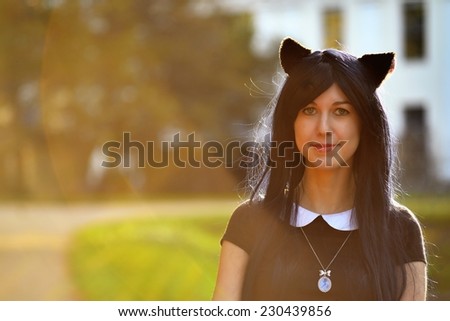 Cute girl with toy cat ears on head in sunbeam light