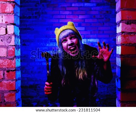 Portrait of funny zombie girl in halloween time with hammer