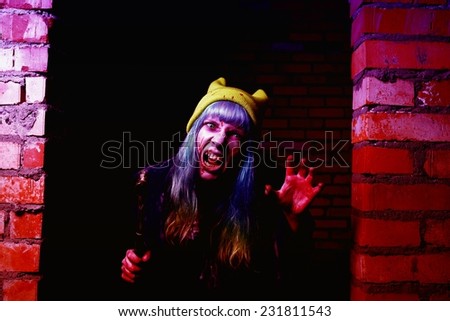 Portrait of funny zombie girl in halloween time with hammer