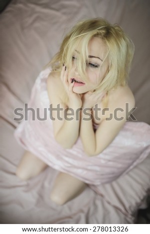 Fashion look on young beautiful girl wakes up in the morning in a bed