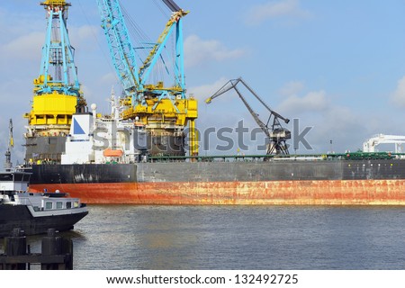 oil tanker and vessel crane in rotterdam harbor