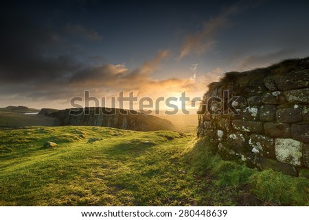 Sunrise at Steel Rigg in Northumberland. Hadrian's Wall is visible prominently in the foreground, as well as into the distance in the background.