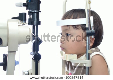 Small boy with slit lamp microscope for eye examination.