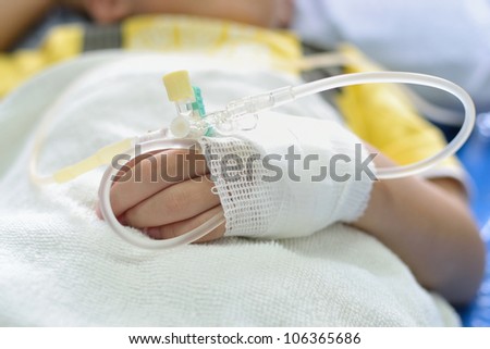 Intra venous fluid line at left arm of boy patient.