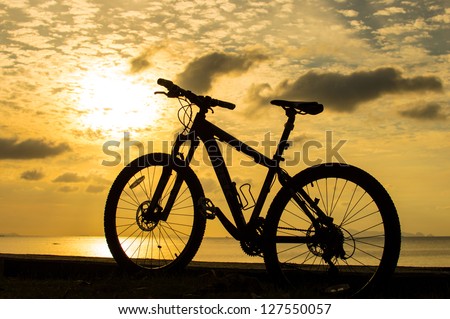 Single mountain bike silhouette on the beach.