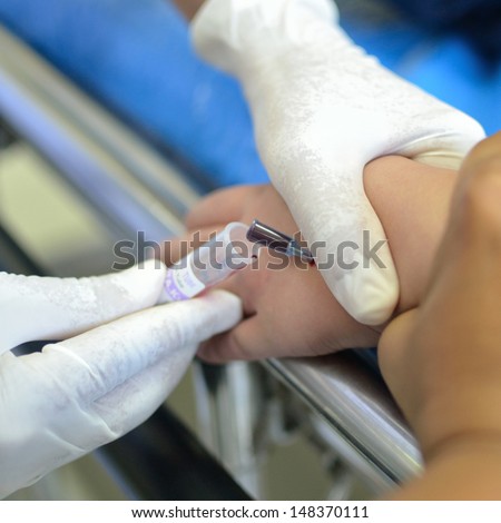 Child patient blood test at left arm on stretcher.