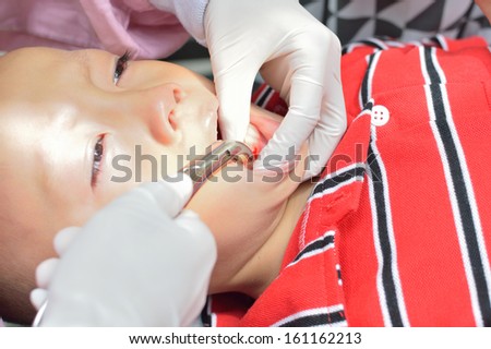 Young asian boy during anethetic injection before dental extraction.