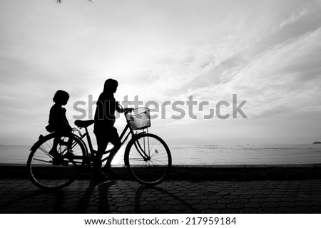 Biker family silhouette , family at the beach at sunset.