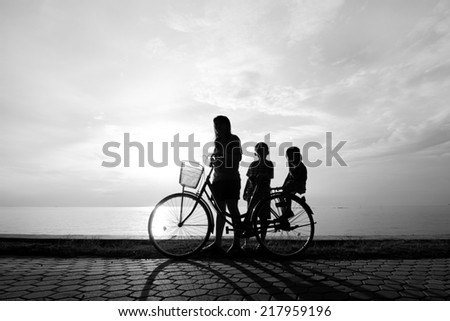 Biker family silhouette , family at the beach at sunset.