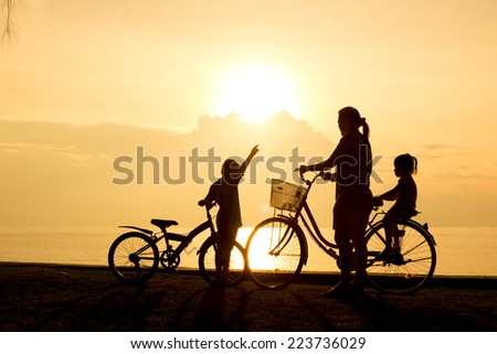 Biker family silhouette , family on the beach at sunset.