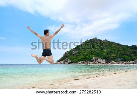 Happy traveler jumping on the beach, ko nangyuan, THAILAND.