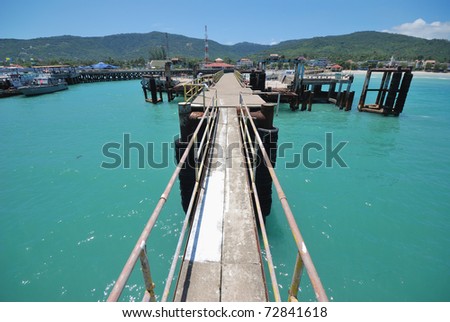 old samui ferry pier with clear water and clear blue sky
