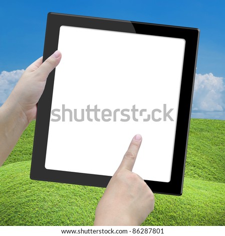 tablet computer with lady hand on nature background.