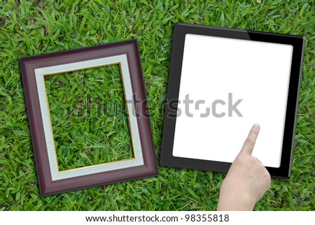 Artwork of tablet computer with hand and photo frame on nature background.
