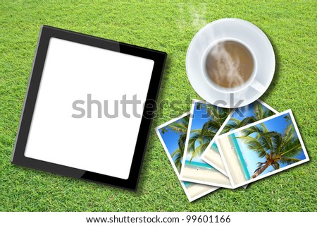 Tablet computer with coffee cup on the nature background.