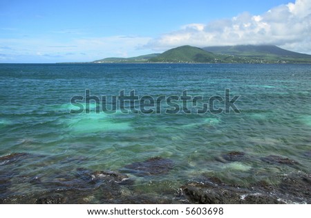 Sparkling blue water with island in the distance and blue sky