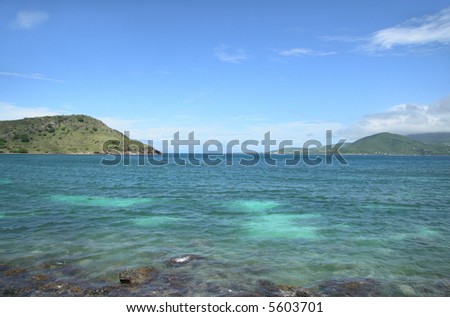 Sparkling blue water with 2 islands and blue sky in the distance 2