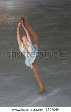 Teenage girl figure skating performance doeing a Bielmann.
